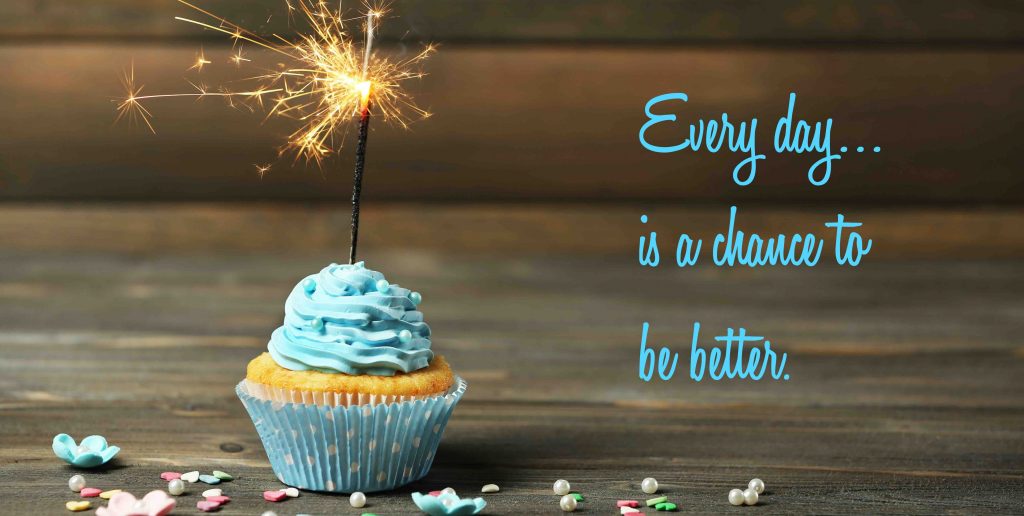 Cupcake with light blue icing and a lit sparkler on top with a quote that says "Every Day is a chance to be better."